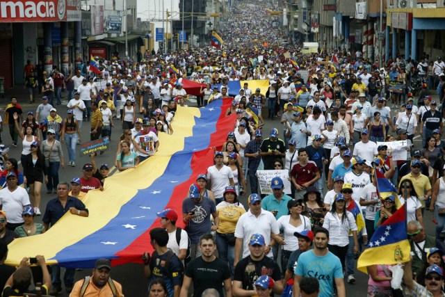Opposition supporters hold a national a flag during a rally against Nicolas Maduro's government in San Cristobal